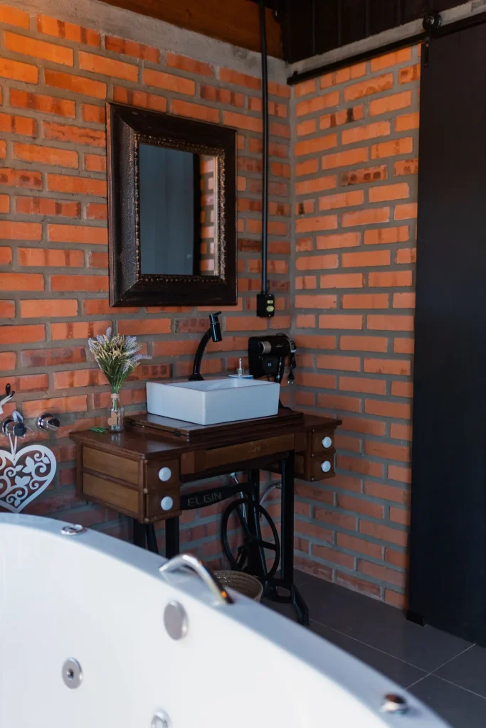 Baño rústico con pared de ladrillo visto